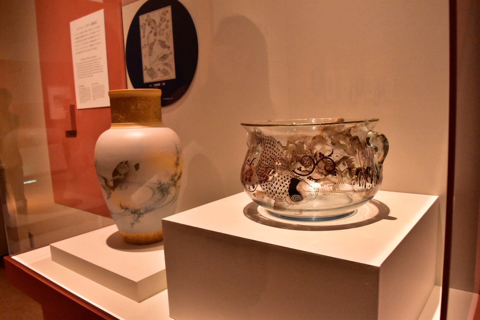 右：エミール・ガレ《双耳鉢：鯉》1878-90年　個人蔵　 左奥：アルバート・ロバート・ヴァレンタイン（絵付）ルックウッド・ポタリー製陶所《花器：金魚》1885年　シンシナティ美術館