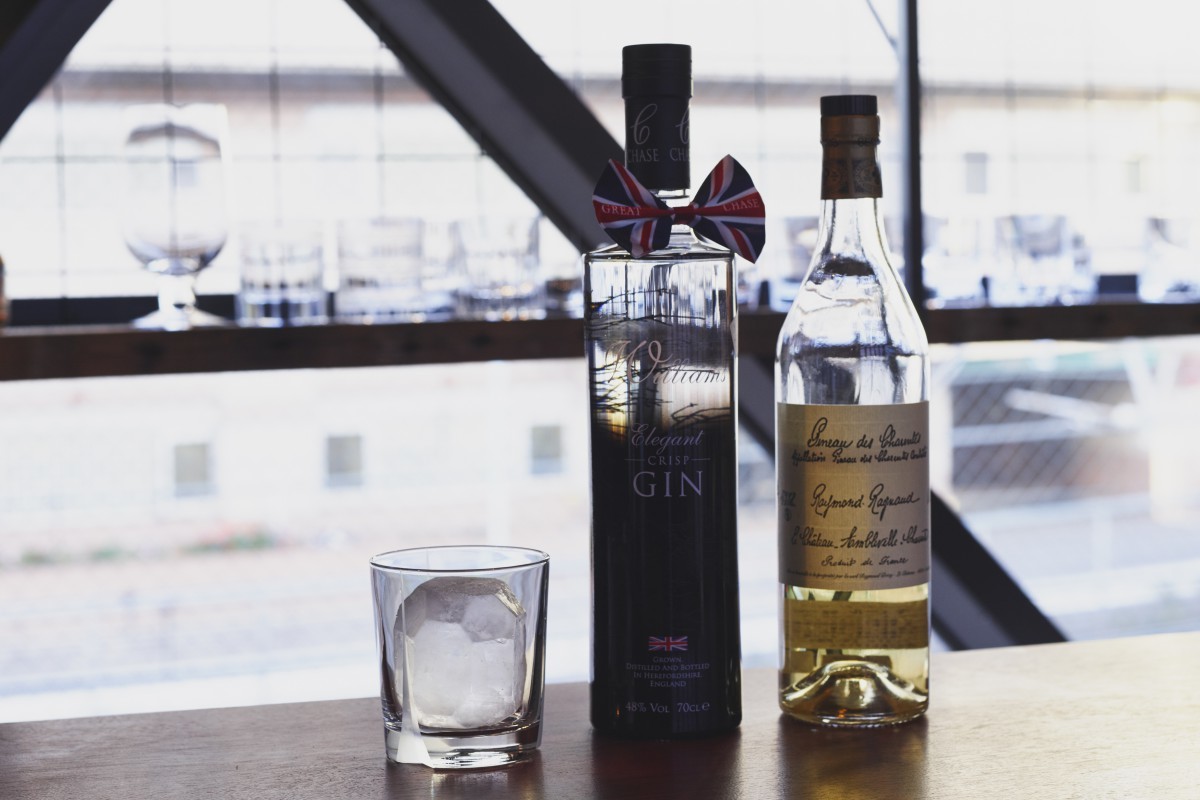 右：コニャック地方の甘口の地酒である、酒精強化ワイン『レイモン ラニョー ヴュー ピノー デ シャラント』。 左：りんごスピリッツベースのジン『チェイス エレガント ジン』。