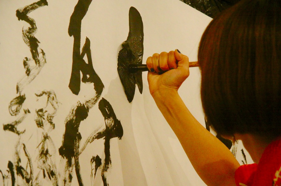時には筆をグーの手で握り、力強く描く場面も