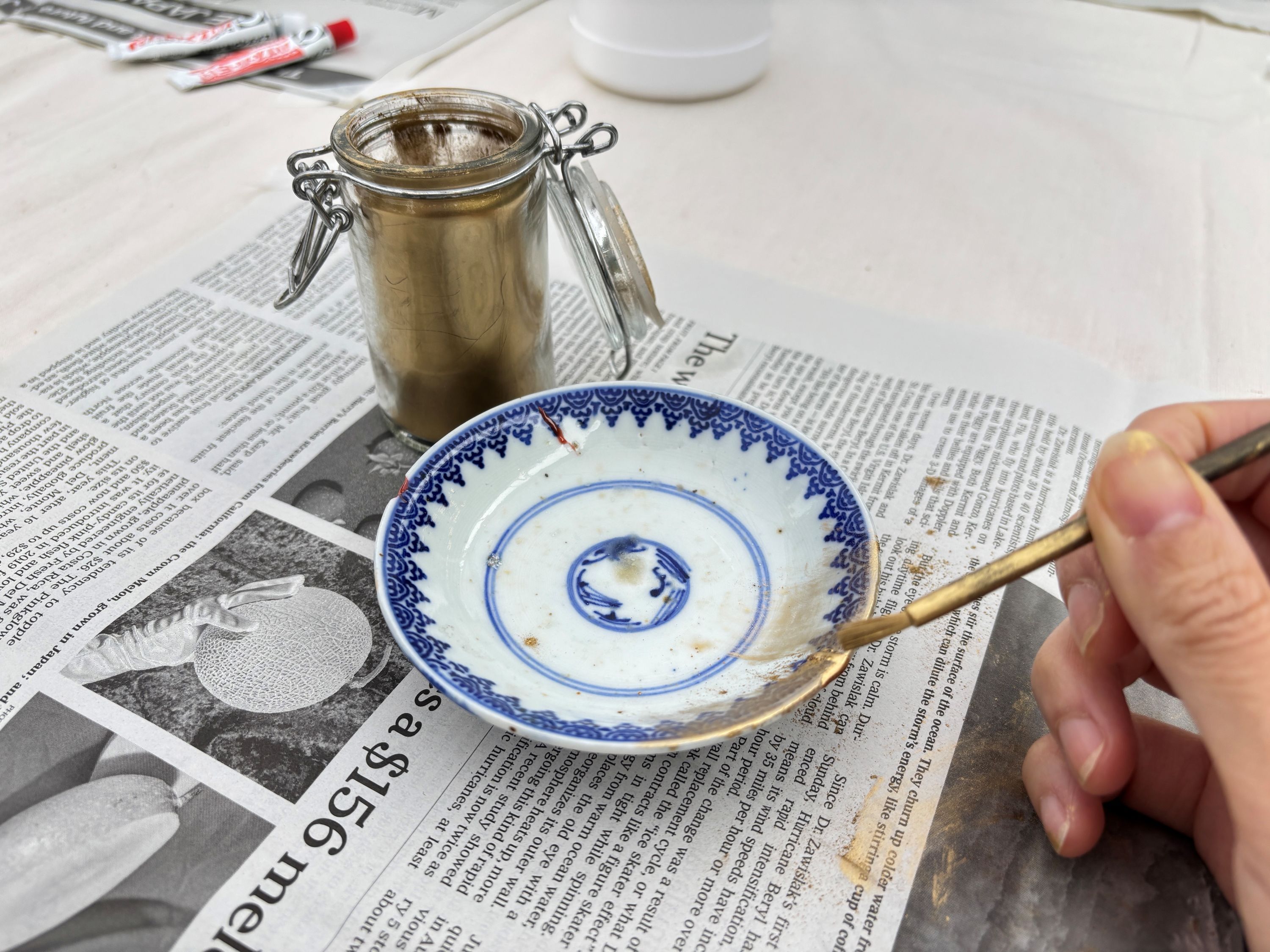 現代金継ぎの作業行程。欠けてしまった部分に真鍮（しんちゅう）粉を付けていく