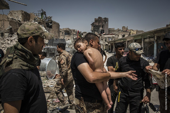 世界報道写真コンテスト　一般ニュースの部　組写真1位　イヴォール・プリケット（アイルランド） ニューヨークタイムズに提供、 2017年7月12日　モスルをめぐる戦闘：イラク軍特殊部隊の兵士によって手当てをうける身元不明の男の子。