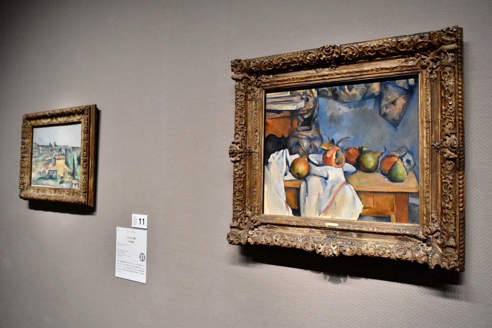 展示風景：右：ポール・セザンヌ　《ザクロと洋梨のあるショウガ壺》　1893年　左奥：ポール・セザンヌ　《ベルヴュの野》　1892-95年　