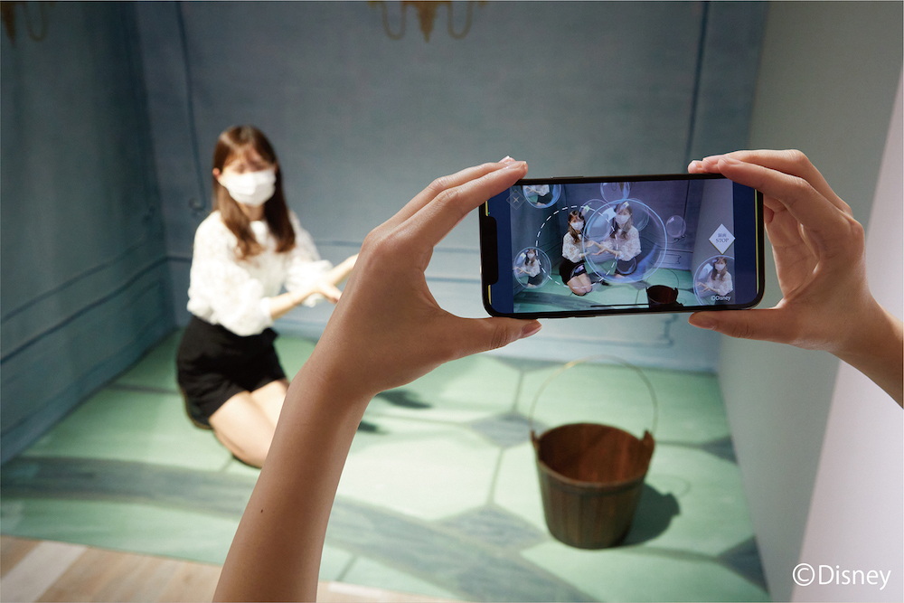 『シンデレラ』より　継母に押し付けられたお掃除の場面。 スマートフォンをかざすと、どんな時でも自分らしく夢を信じて輝くシンデレラが、シャボンの泡に浮かび上がるシーンを体験できます。