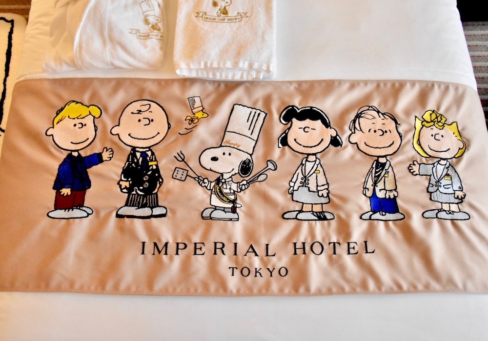 帝国ホテルの制服姿の“ピーナッツの仲間たち”があしらわれたベッドスローは、デザイナー・芦田多恵氏が手がけた。
