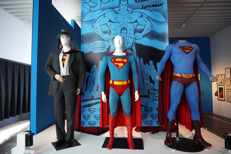 左より：《クラーク・ケント/スーパーマンのコスチューム》（映画『スーパーマンⅡ　冒険篇』（1980年））、《スーパーマンのコスチューム》（映画『スーパーマン』（1978年））、《スーパーマンのコスチューム》（映画『スーパーマン・リターンズ』（2006年）） DC SUPER HEROES and all related characters and elements (C) & TM DC Comics. WB SHIELD: (C) & TM WBEI. (s21)