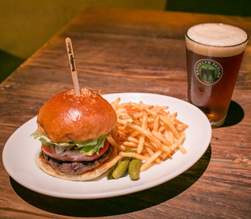 Brooklyn Parlorは、日本で初めてブルックリン・ラガーをドラフトで提供したお店でもある。人気メニューのブルックリンラガーと肉の食感を残したジューシーなハンバーガー。