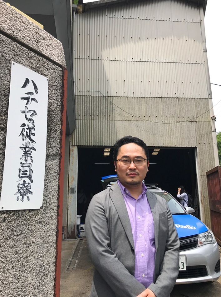 あごうさとし。現在新劇場の開設を進めている倉庫の前にて。 ［撮影］吉永美和子