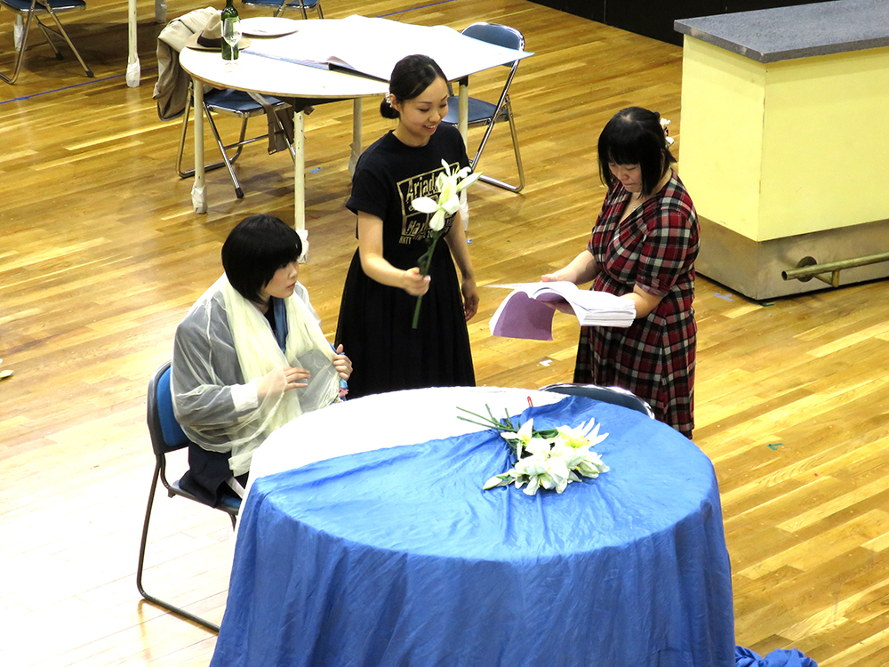 （左から、作曲家役、ツェルビネッタ役、演出助手。机の上に置かれているのは百合の花だ。） （撮影：小室敬幸）