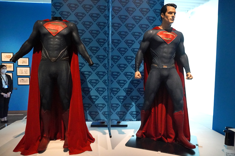 左より：《スーパーマンのコスチューム》（映画『マン・オブ・スティール』（2013年））、《スーパーマンのコスチューム》（映画『バットマン ＶＳ ス―パーマン　ジャスティスの誕生』（2016年）） DC SUPER HEROES and all related characters and elements (C) & TM DC Comics. WB SHIELD: (C) & TM WBEI. (s21)