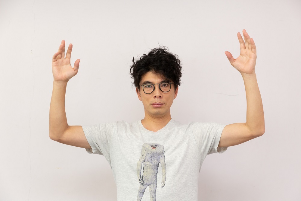ジャミラのTシャツを着て、キングジョーのポーズ 撮影：大塚正明