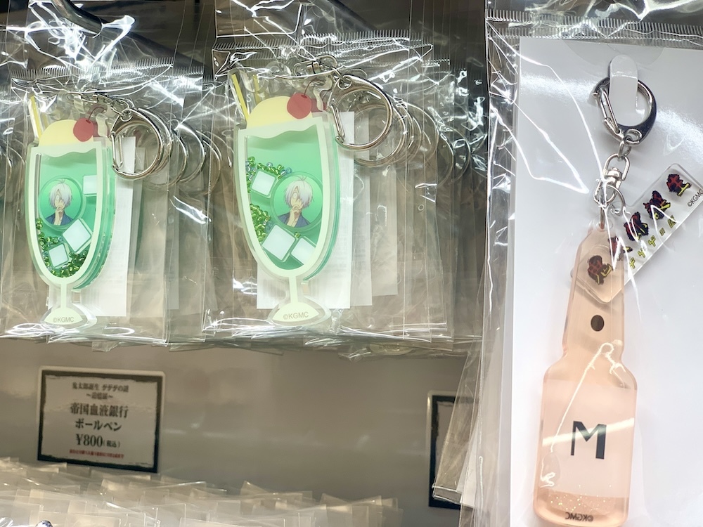 左：クリームソーダ風シャカシャカアクリルキーホルダー ¥1,000（税込）、右：血液製剤M風グリッターキーホルダー ¥1,000（税込）