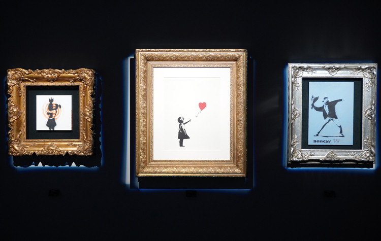 『バンクシー展』会場風景。左より：《Bomb Love》、《Girl with Balloon》、《Love Is In The Air》。