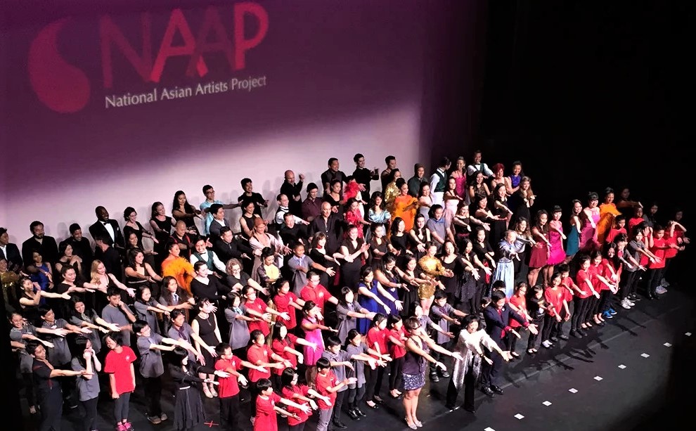 2015年に行われた、NAAPガラ公演のフィナーレ。総勢約150名のパフォーマーやスタッフが舞台に登場した。最前列中央がリー。