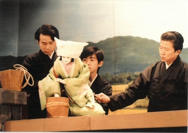 1978年１月、朝日座での若手向上会『菅原伝授手習鑑』佐太村の舞台稽古にて。梅王丸の女房・春の主遣いを勤める簑二郎を、師匠の簑助が左遣いとして補佐してくれた。足は吉田和右。 　　　　　 提供：吉田簑二郎