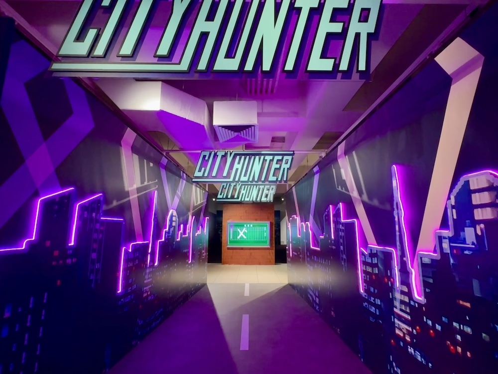 新宿の街並みをイメージした導入部分。奥には「XYZ」と記された伝言板が。