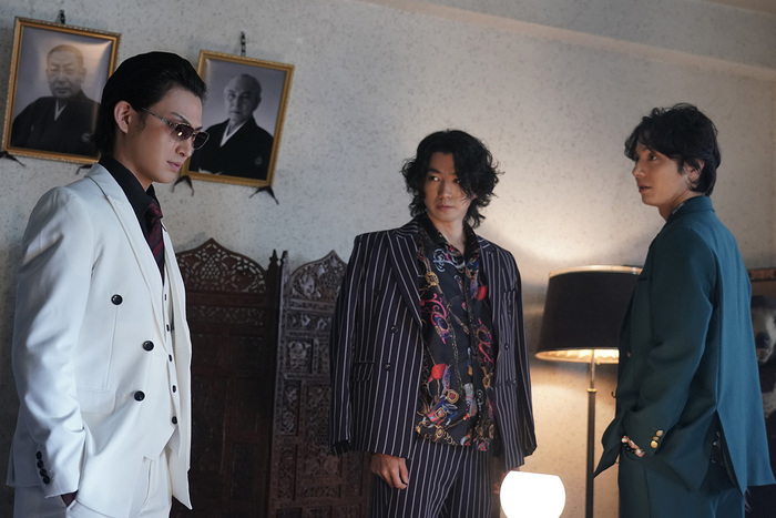 大友一平と高梨明が村田組若頭・村田恭次の表情を伺う姿