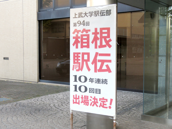 伊勢崎キャンパスの正面玄関をくぐると、駅伝部の功績を讃えた看板が目に入る