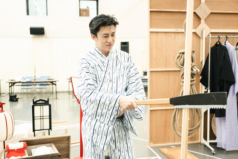 小道具ののこぎりと、松本幸四郎さん。狂言作者花桐冬五郎役をつとめる。