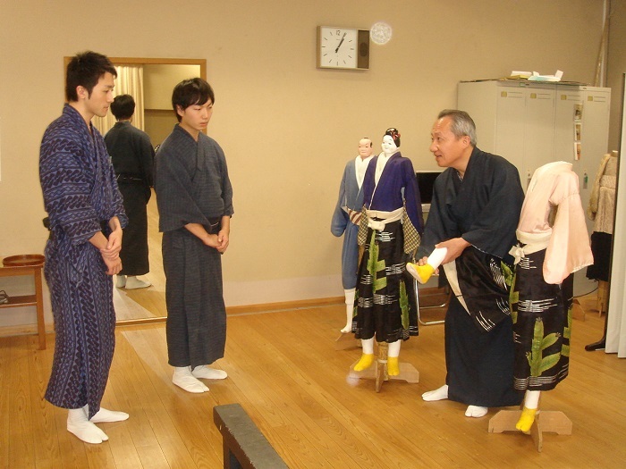 同期の桐竹勘昇と共に桐竹勘十郎の指導を受ける研修生時代（上）と、第26期文楽研修生修了発表会で足を遣う玉征さん（主遣いは吉田一輔）。