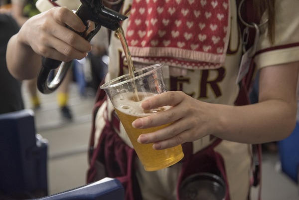 売り子さんはさすがプロ！ 巧みな手つきでビールを注いでくれる。