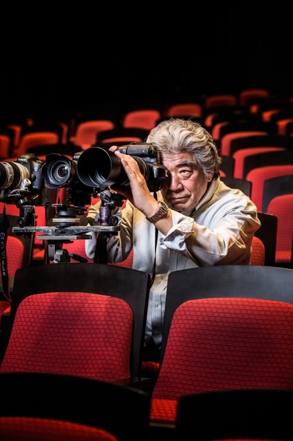 舞台で写真を撮影中の谷古宇正彦氏。両目を開いたまま、被写体を狙う。 撮影／Shinichiro Saigo