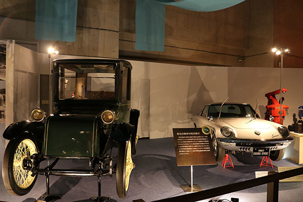 左：Milburn（ミルバーン）電気自動車　1920（大正9）年ごろ、国立科学博物館所蔵　　右：マツダ　コスモスポーツ　1967（昭和42）年、国立科学博物館所蔵