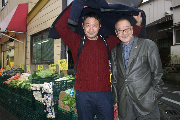 左から戌井昭人、流山児祥。2016年12月、東京・早稲田にある八百屋の前にて。