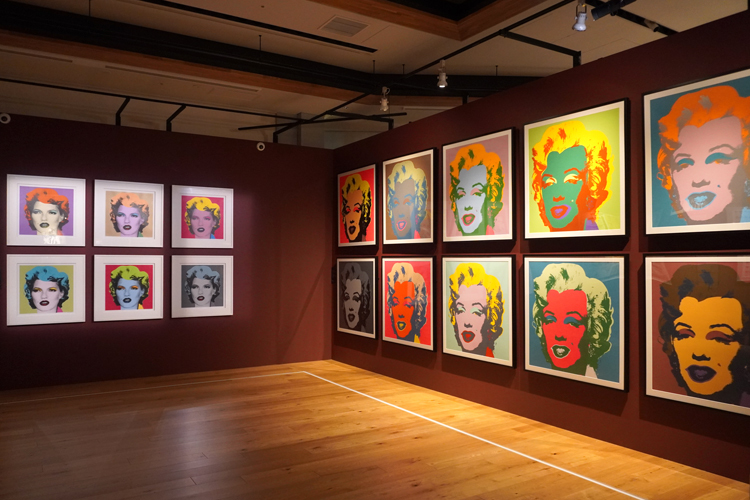 『バンクシー展　天才か反逆者か』展示風景。左6作品がバンクシーの《ケイト・モス》、右の作品がウォーホルの《マリリン・モンロー　サンデー・B・モーニング・エディション》。