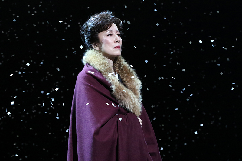 舞台の上で紙吹雪が舞う中悲しそうな表情で見つめる高畑淳子