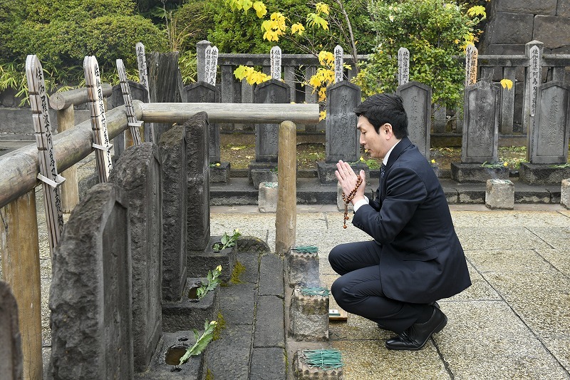杉野十平次の墓に手を合わせる坂東亀蔵