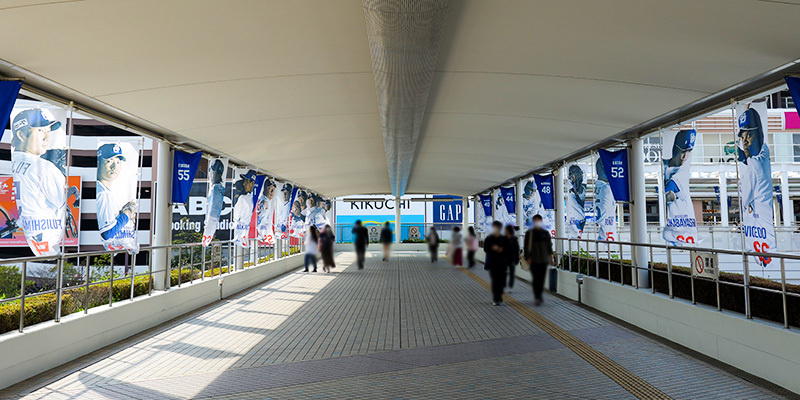 地下鉄ナゴヤドーム前矢田駅から続くペデストリアンデッキのドーム側エントランスに設置された、主力選手のオリジナルのぼり旗　※昨年の実施風景