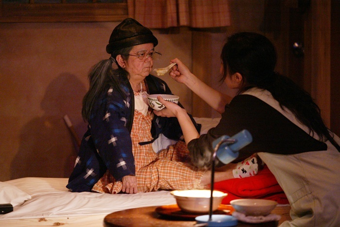 庭劇団ペニノ『笑顔の砦』初演より。左側が介護老人を演じたマメ山田。