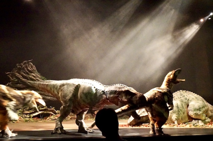 群がるダコタラプトルたちを相手に格闘する、若いティラノサウルス