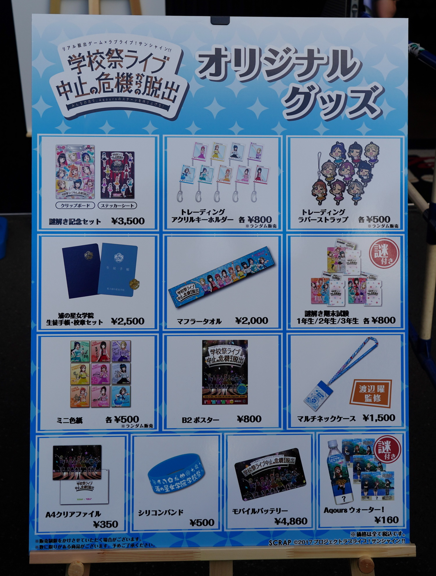 ここでしか手に入らないイベントグッズも色々。ゲーム中で貸してもらえるマルチネックケースは同じ物が購入可能。使い勝手も良く思い出にもなるのでオススメだ (C)2017 プロジェクトラブライブ！サンシャイン!!／(C)SCRAP