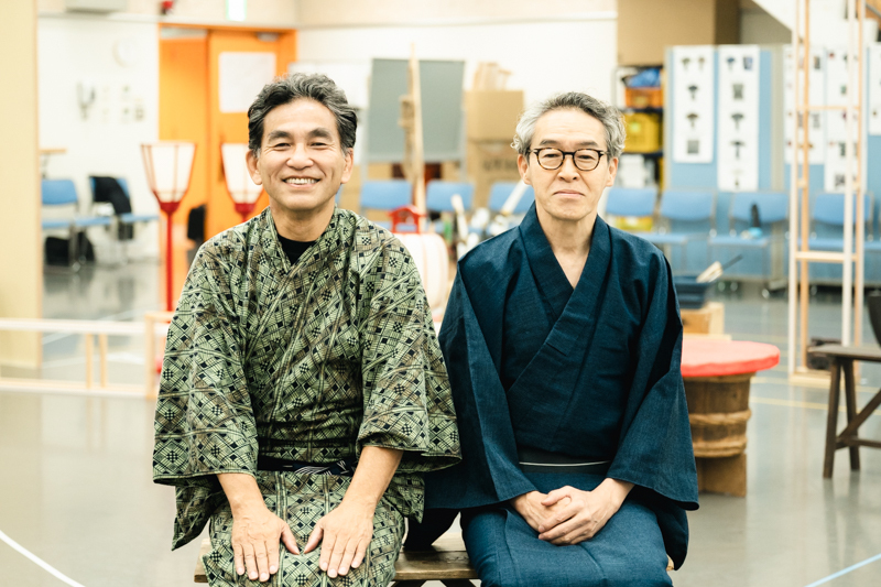 （左から）大道具方儀右衛門役の阿南健治さん、骨つぎ玄福役の浅野和之さん