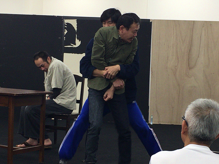 左端が木原役の筑波。近藤を押さえるのは三塚の相棒の刑事役、中島歩