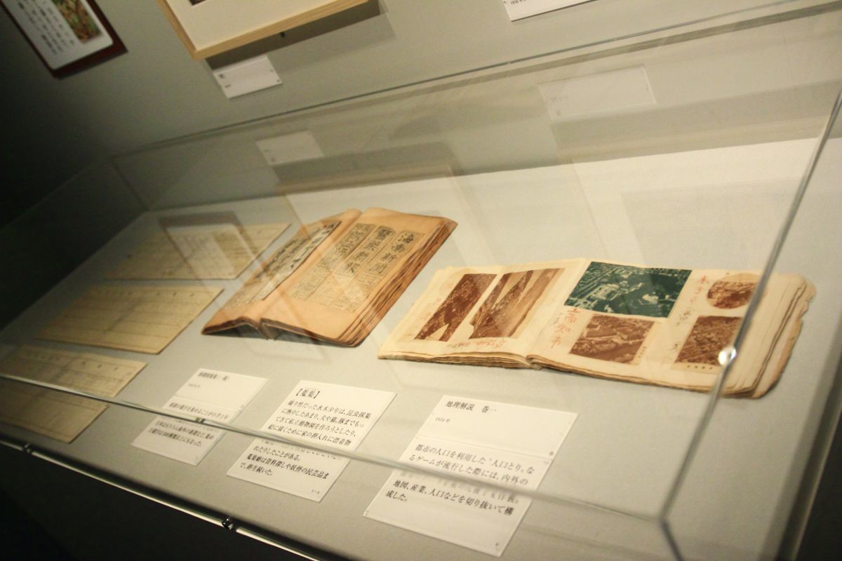 左 小学生時代の通知表 昭和4年～11年（1929年～1936年）　中 新聞図案集（一集） 昭和6年（1931年）頃　右 地理解説　巻一 昭和９年（1934年）