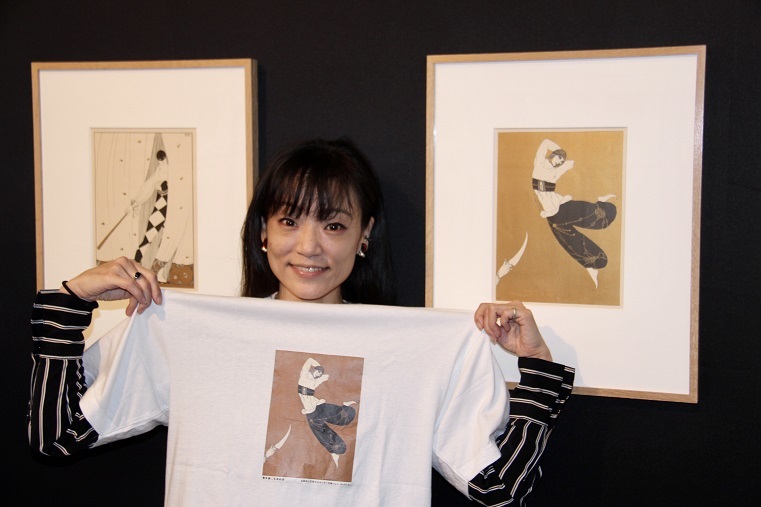 薄井憲二の米寿を記念して作ったＴシャツを手にするキュレーター関典子 　　　　(C)H.isojima