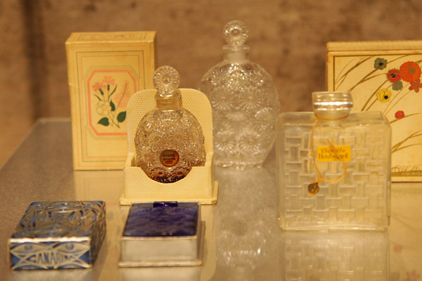 （左手前から時計回りに）香水瓶《青い目》カナリナ社 1928年 共箱付、香水瓶《リラ》ウォルト社 1937年 共箱付、香水瓶《バラ》ウォルト社 1937年、香水瓶《すみれ》ウビガン社 1919年 共箱付