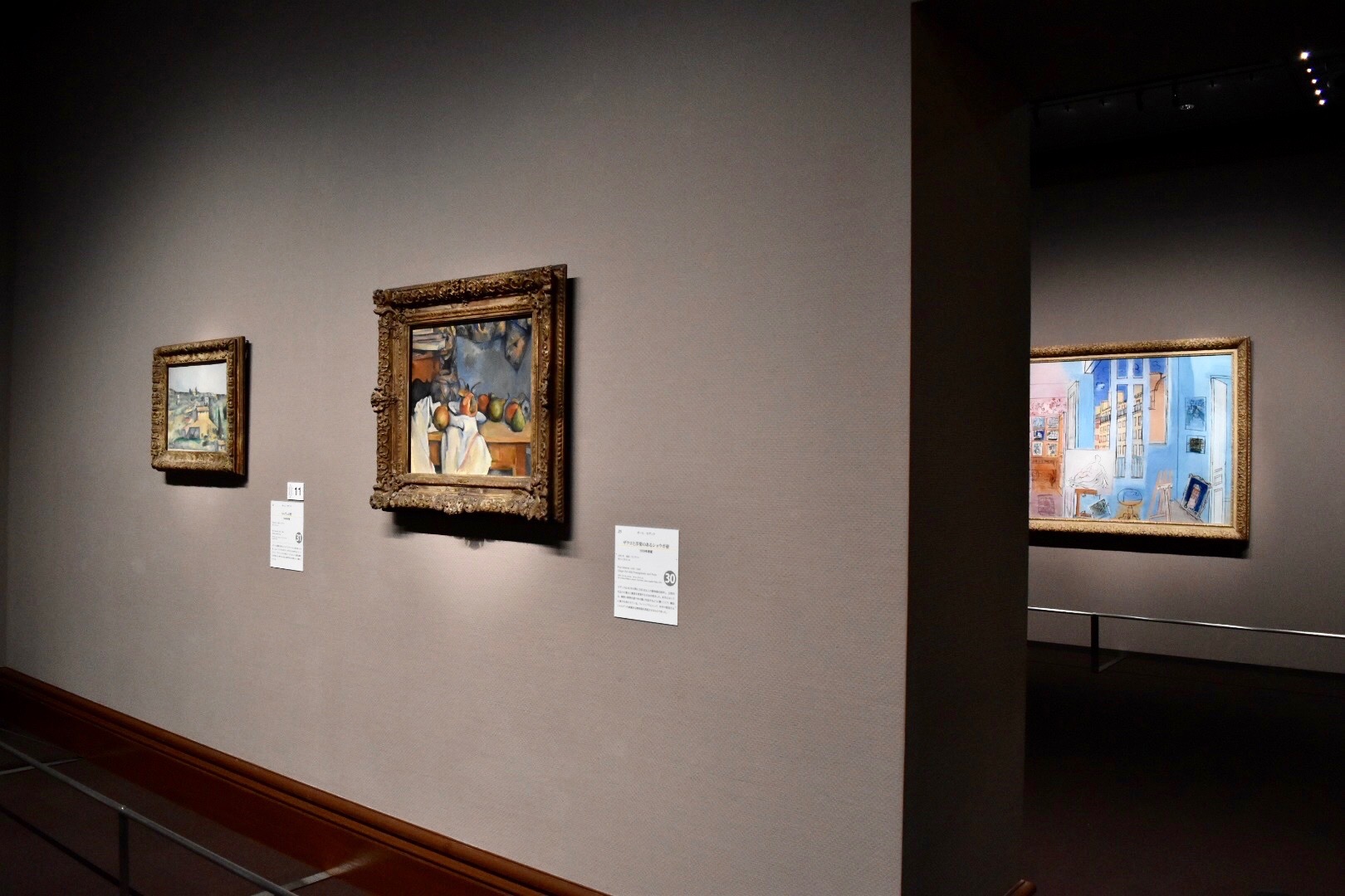 展示風景：手前右：ポール・セザンヌ　《ザクロと洋梨のあるショウガ壺》　1893年　手前左：ポール・セザンヌ　《ベルヴュの野》　1892-95年　奥：ラウル・デュフィ　《画家のアトリエ》　1935年