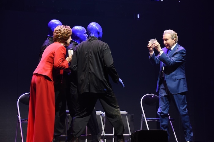 『ブルーマングループ2025新宿公演』プレスショーの様子。ブルーマンと小林幸子の写真を撮る、デーブ・スペクター（右）