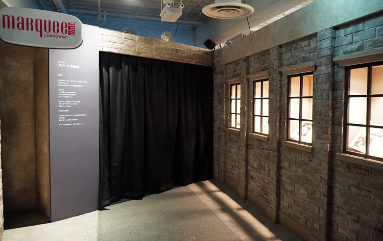 【SCENE1】の展示風景。セットの看板や煉瓦がレトロな雰囲気。