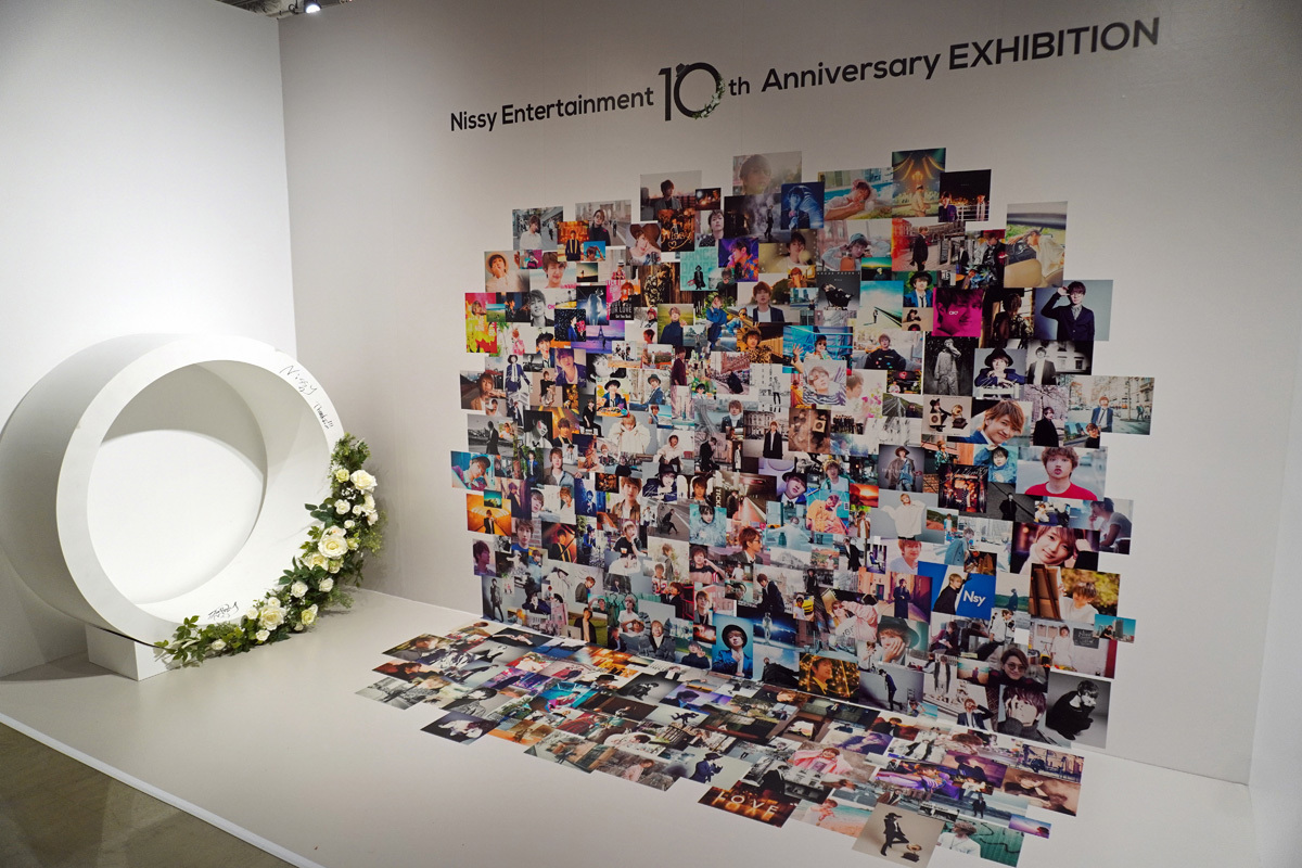 フォトスポット。10周年の活動が詰め込まれた写真を背景に。