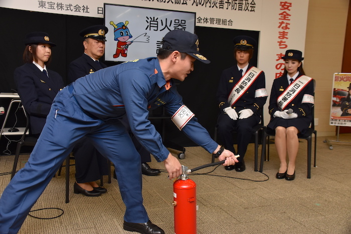 消火器の使い方を学ぶ浦井健治と夢咲ねね（右奥から2番目、右奥）