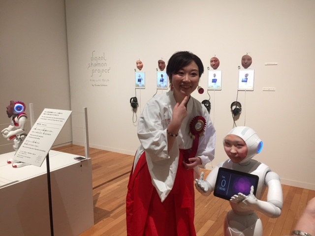 市原えつこ氏と彼女の顔を3Dで映し出した、ロボットのPepper