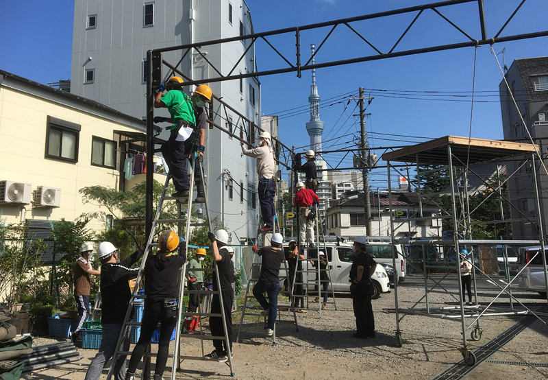 テント劇場設営の様子。彼方には東京スカイツリー。  （写真提供：劇団唐ゼミ☆）